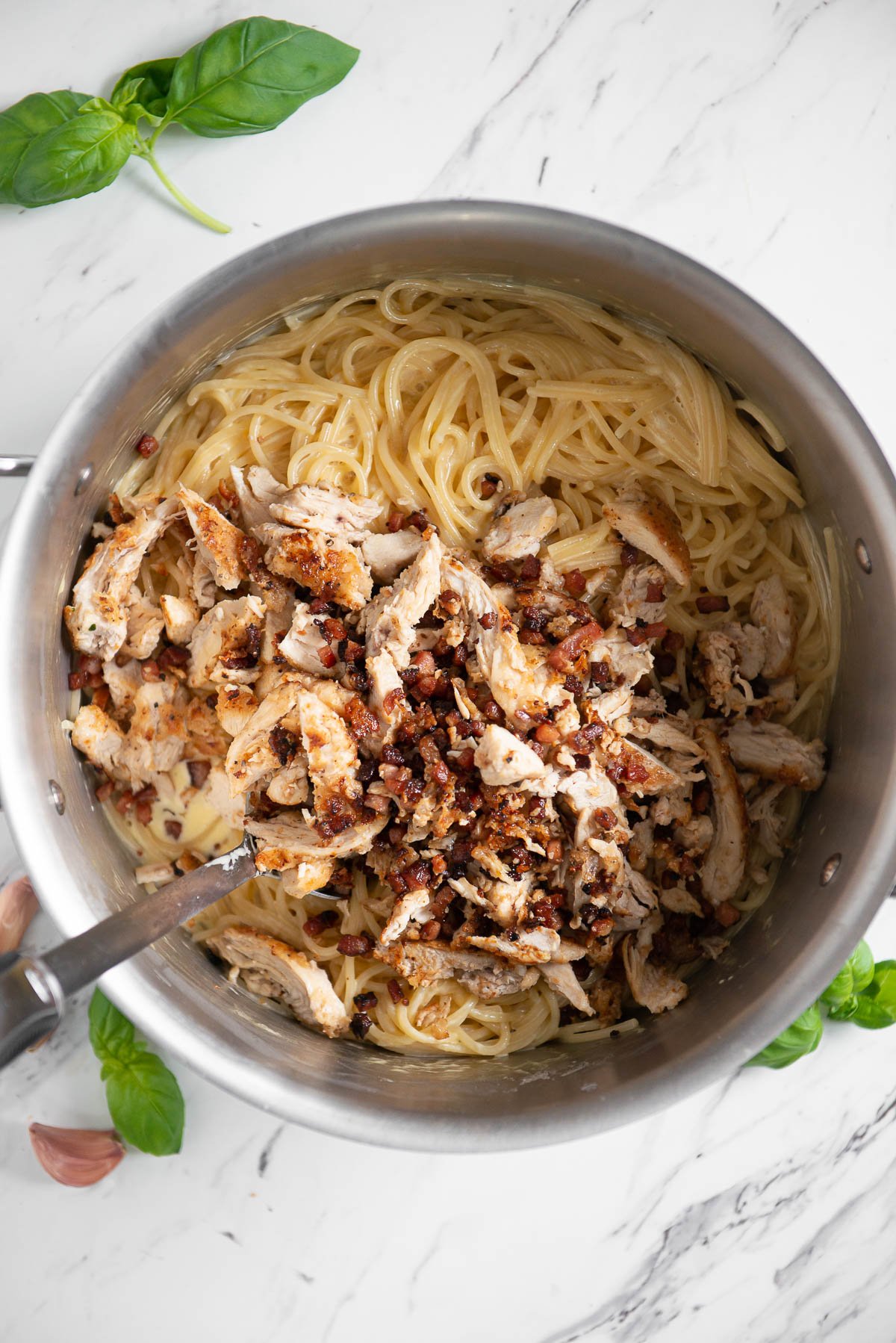 pasta carbonara with cooked chicken and bacon.