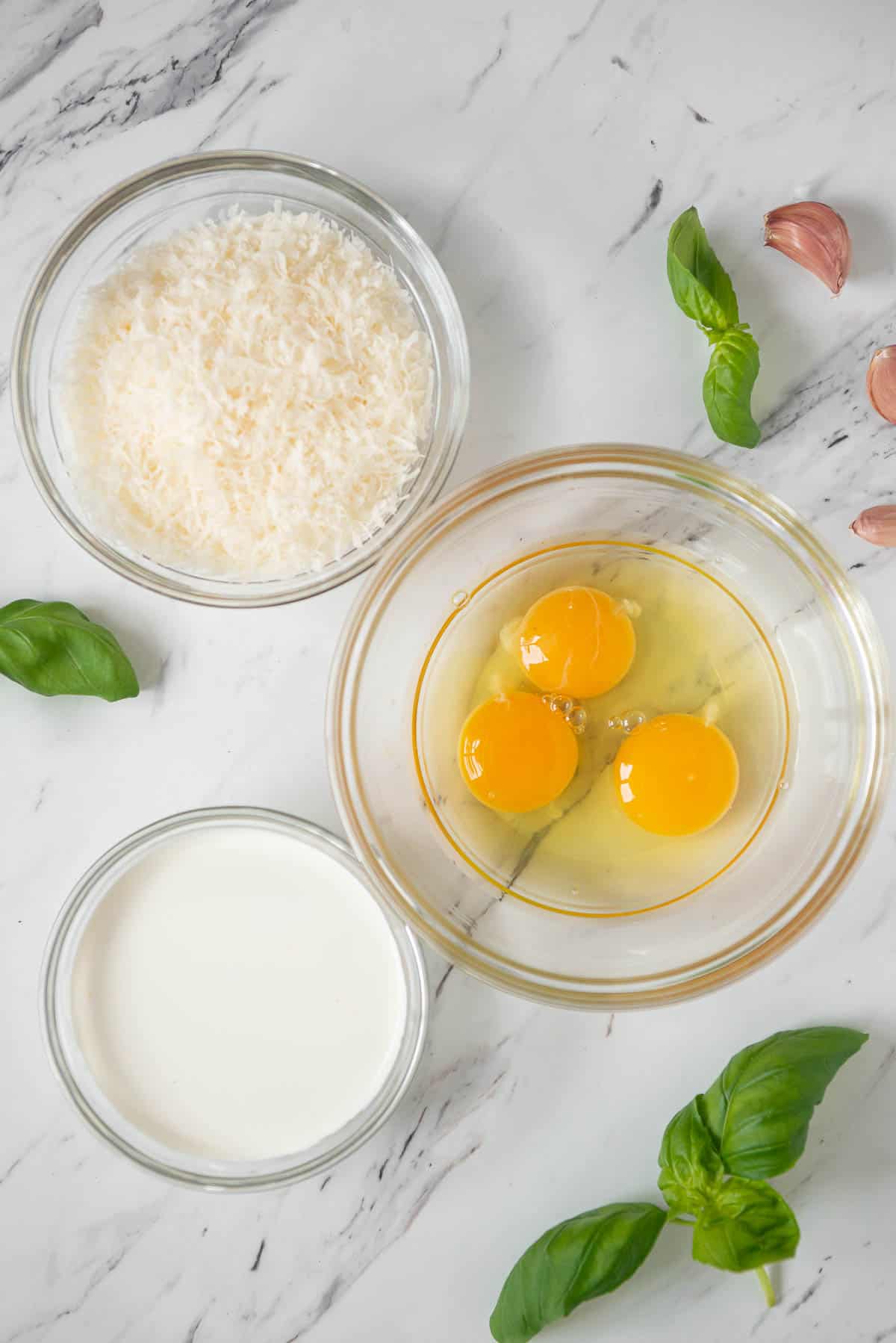 bowls of parmesan, eggs, and cream for carbonara recipe.