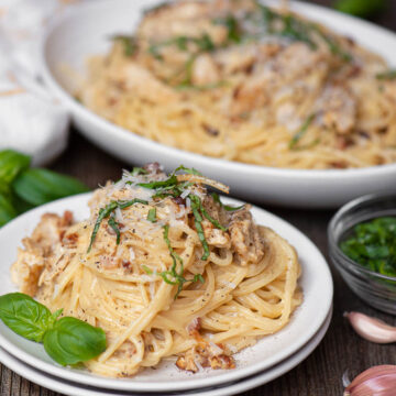 chicken carbonara on plate with basil.