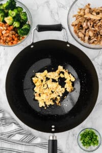 scrambled egg in wok pan for chicken fried rice recipe.