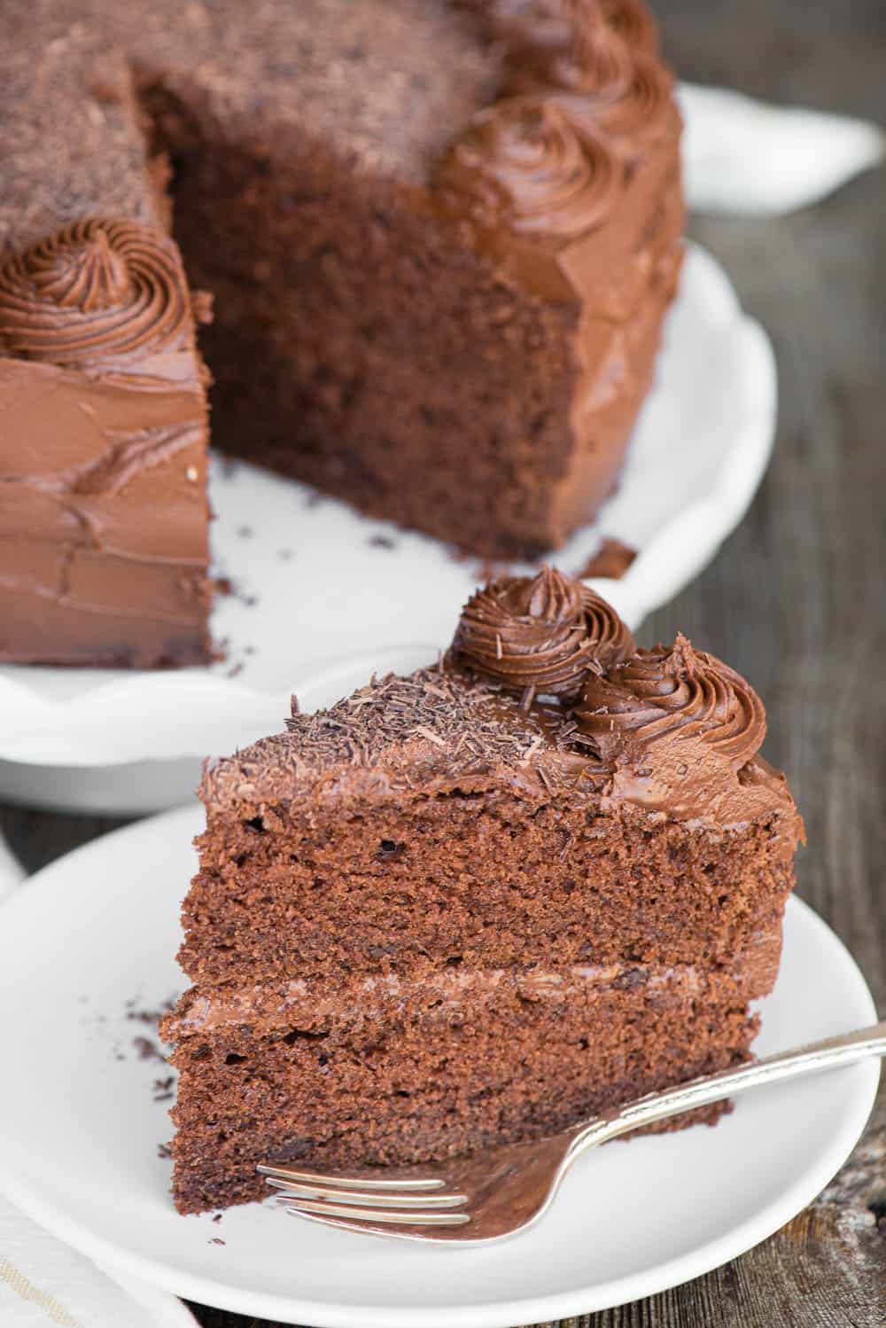 slice of Chocolate Cake on white plate with chocolate frosting