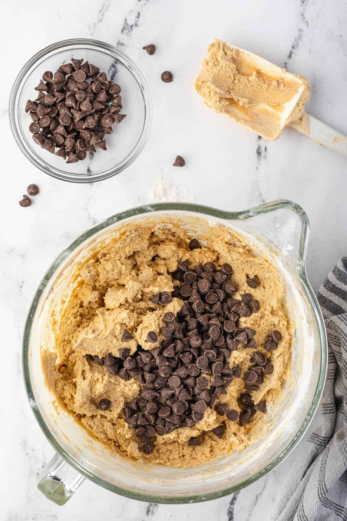 adding chocolate chips to peanut butter cookie dough