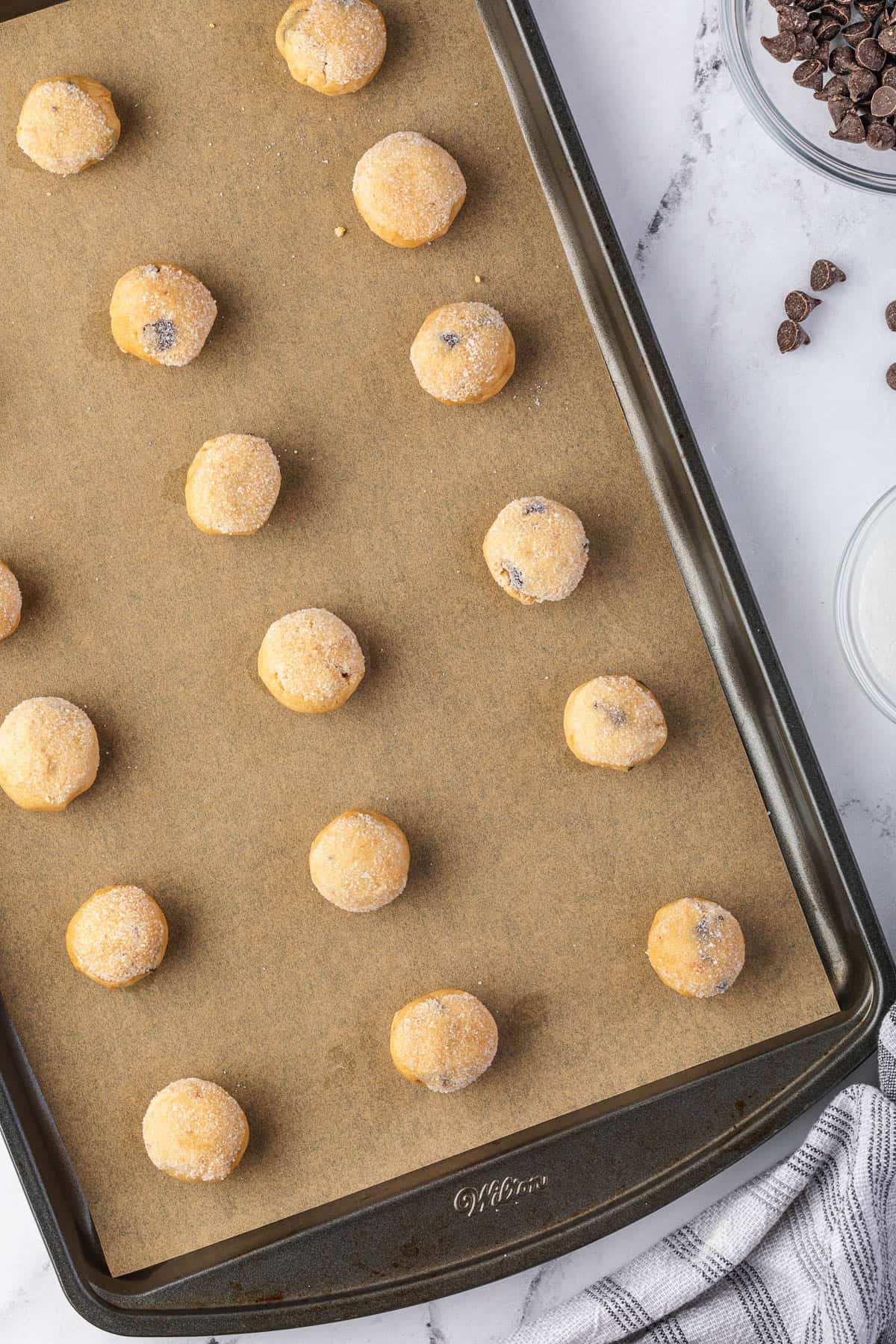 balls of chocolate chip peanut butter cookie dough on parchment lined pan