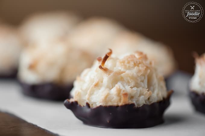 side view of a homemade coconut macaroon with the bottom dipped in chocolate