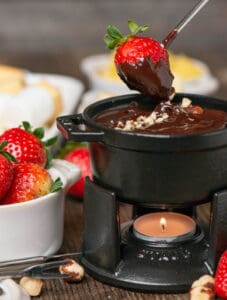 dipping strawberry into chocolate fondue.