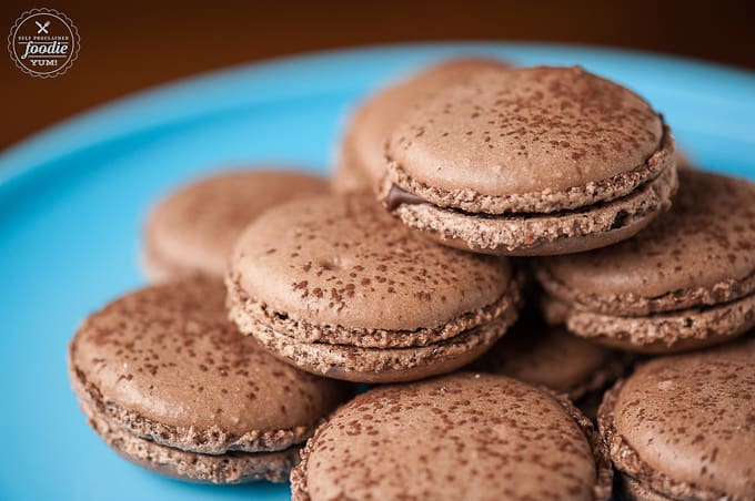 stack of chocolate filled macarons on blue plate