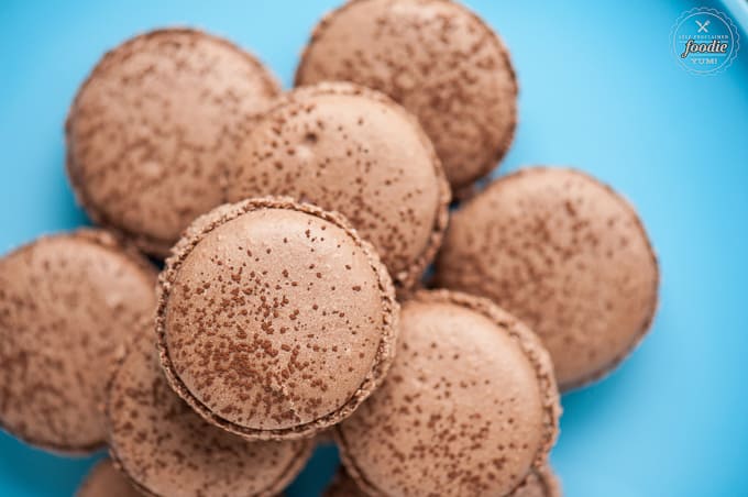 stack of Chocolate Macarons on blue platter