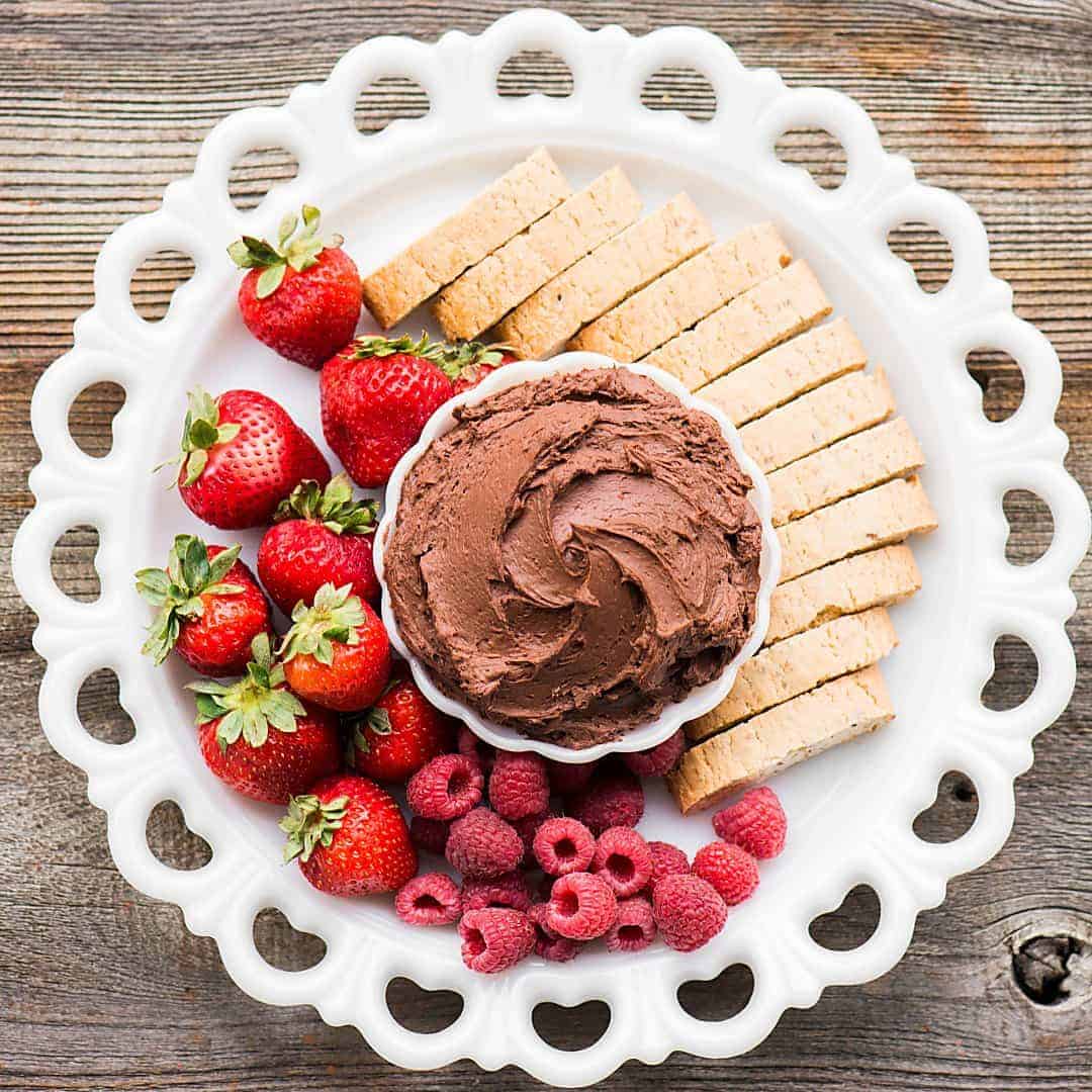 Easy fruit dip with cream cheese and chocolate on platter with fruit and biscotti