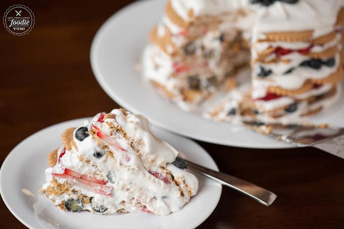 A piece of icebox cake made with coconut cookies and berries on plate