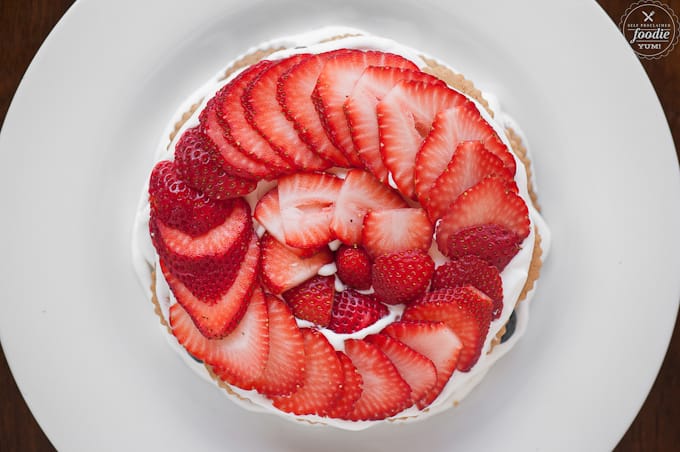 thinly sliced strawberries on cream in circle pattern