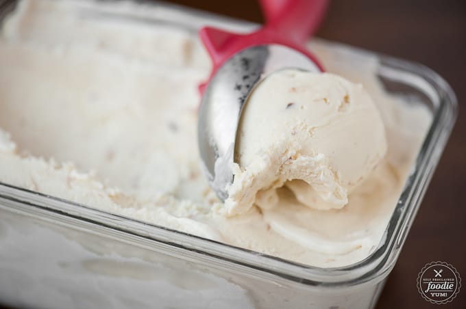 scooping homemade coconut ice cream out of dish