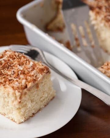 A slice of coconut poke cake on plate