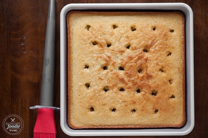 vanilla cake in pan with holes punched into it for a poke cake recipes