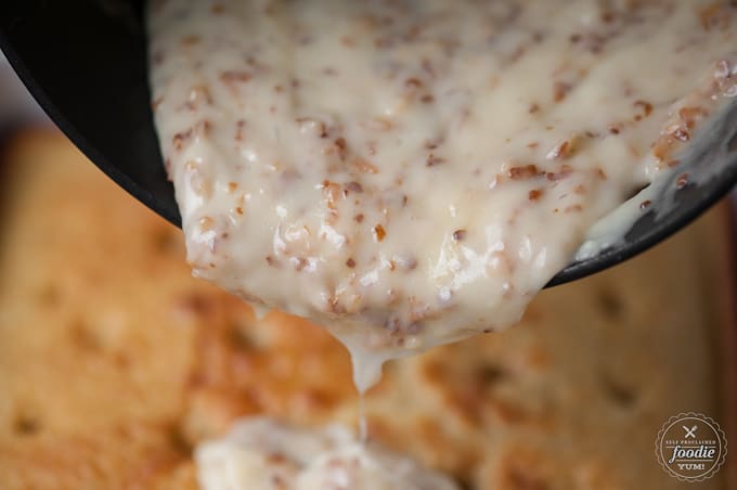 creamy coconut topping getting added to vanilla cake