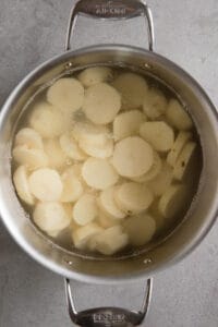 sliced potatoes in pot covered in water