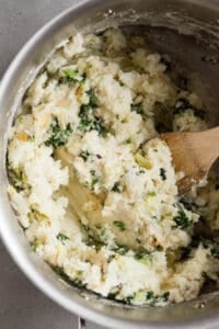 mixing cooked greens into mashed potatoes