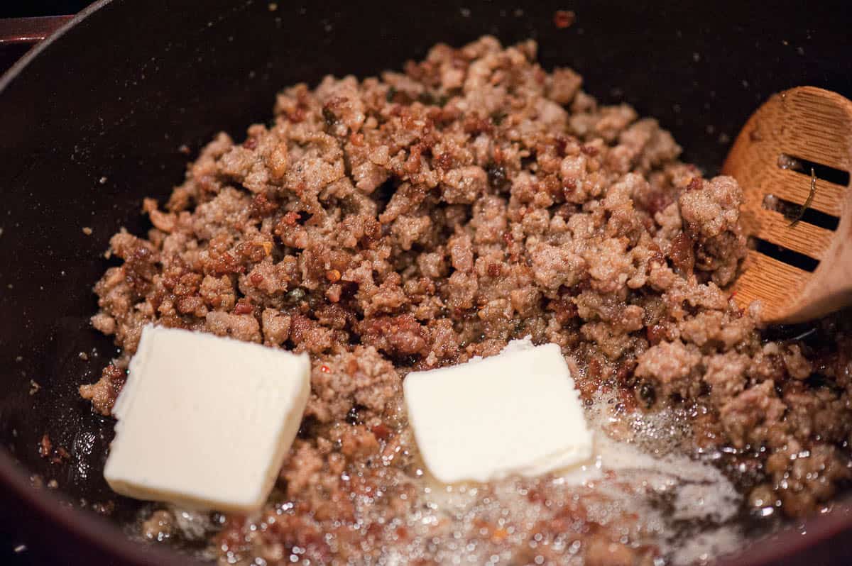 adding butter to browned bulk breakfast sausage.