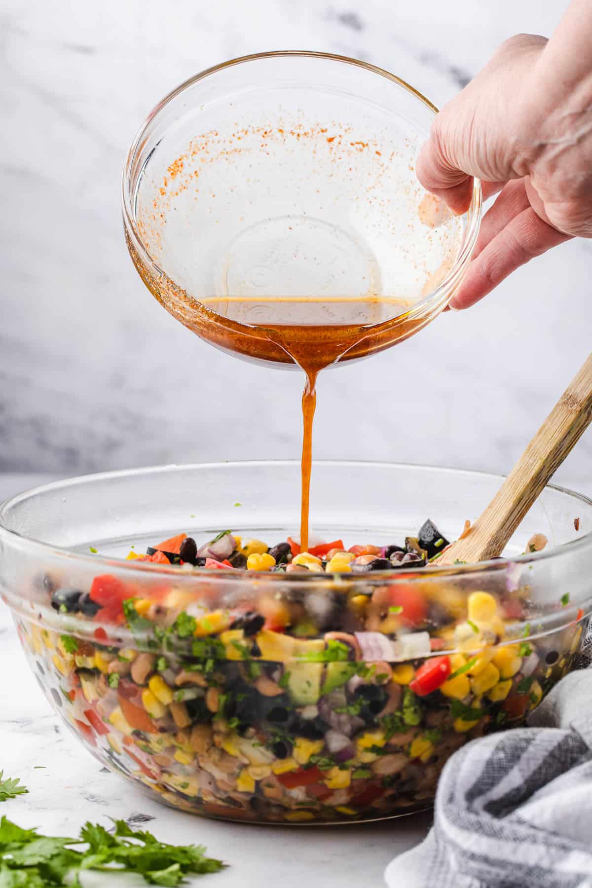 pouring vinaigrette onto Cowboy Caviar salad