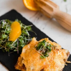 crab melt on black tray topped with cheese