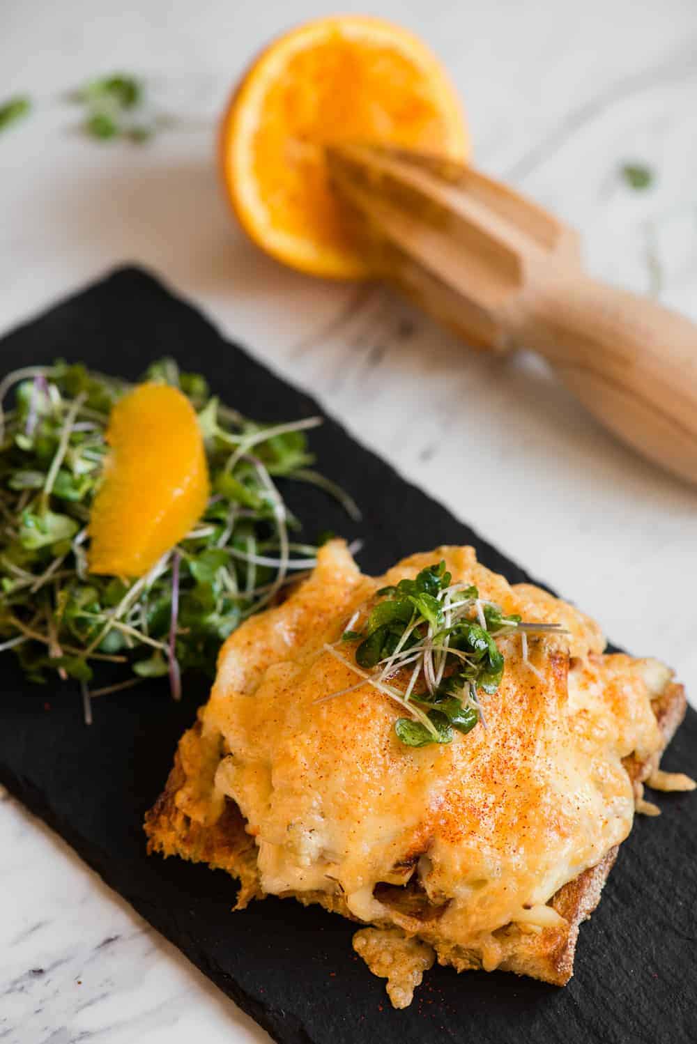 crab melt on black tray topped with cheese