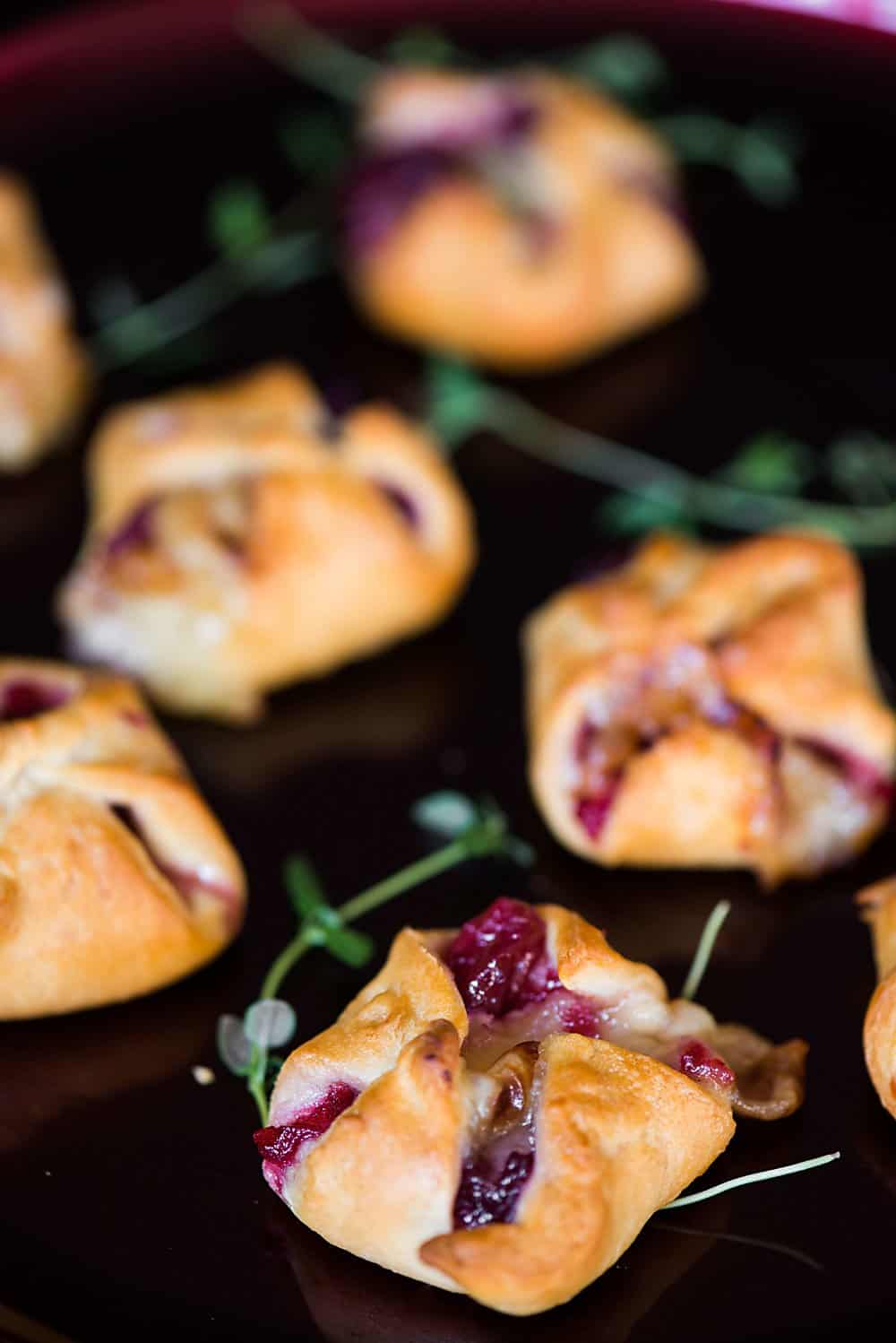 Cranberry Brie Bites are an easy three ingredient appetizer that are perfect for holiday parties. Warm and delicious - everyone will love them!