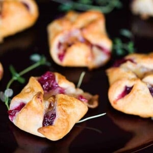 Cranberry Brie Bites are an easy three ingredient appetizer that are perfect for holiday parties. Warm and delicious - everyone will love them!