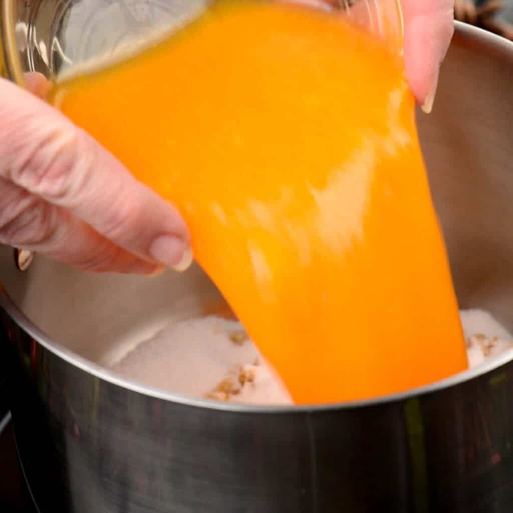 pouring orange juice into pan