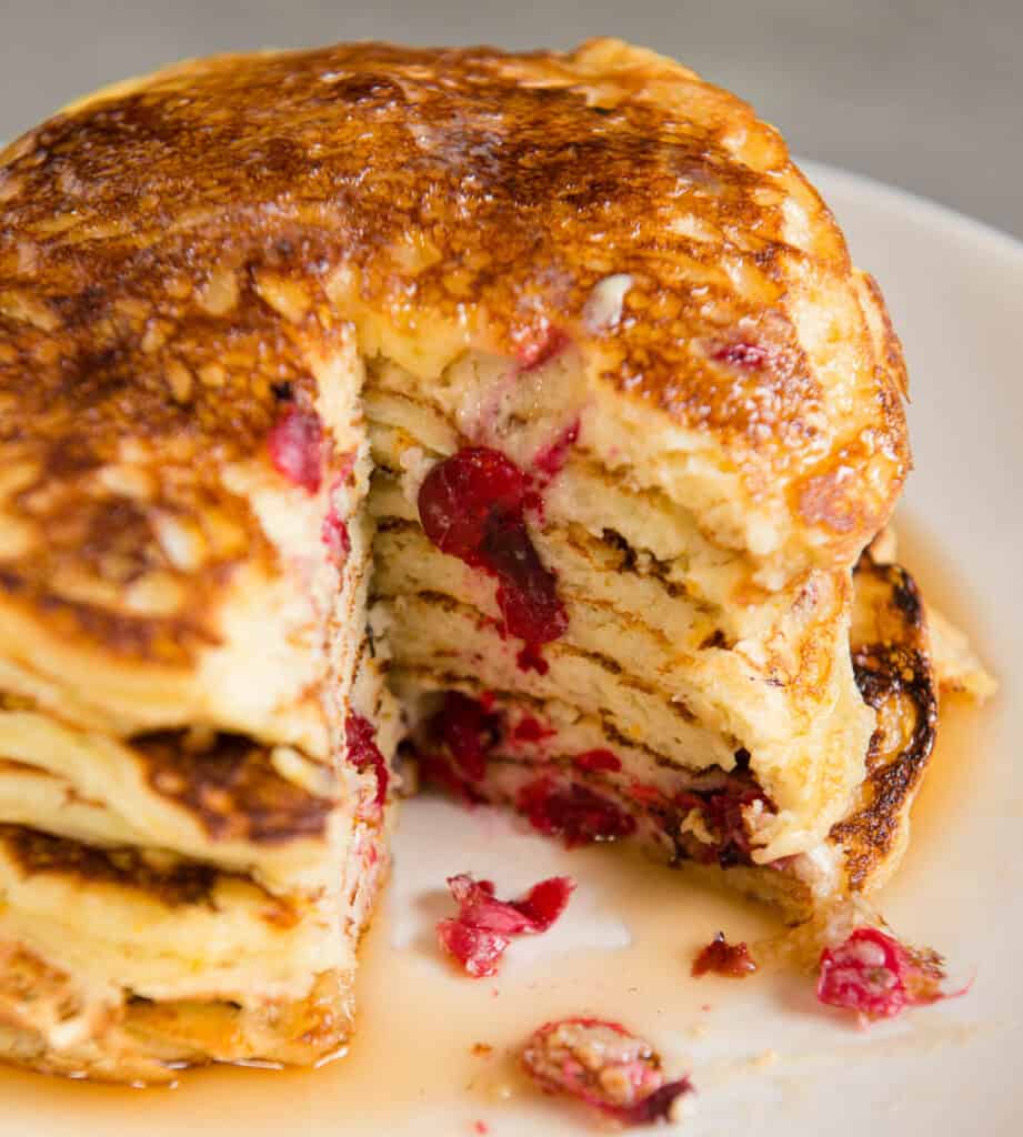 huge stack of cranberry Buttermilk Pancakes with a bite cut out