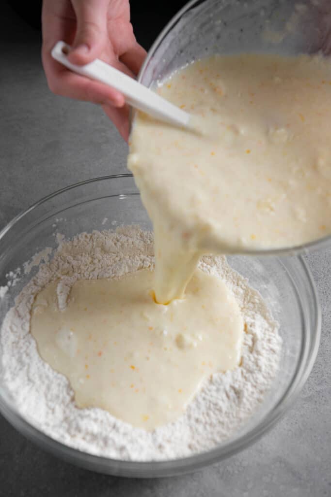 adding wet ingredients to dry ingredients for pancake recipe