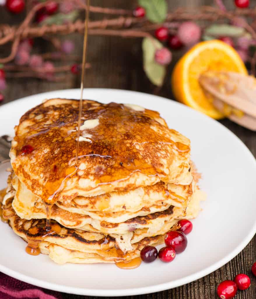 stack of cranberry Buttermilk Pancakes with a stream of syrup