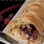 Warm Cranberry Pecan Brie en Croute wraps buttery puff pastry around brie, fresh cranberry sauce, and candied pecans to make the perfect holiday appetizer.