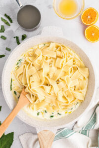 adding pappardelle pasta to lemon cream sauce.