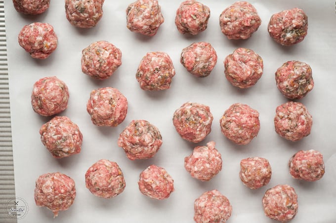 uncooked stuffed meatballs on baking sheet