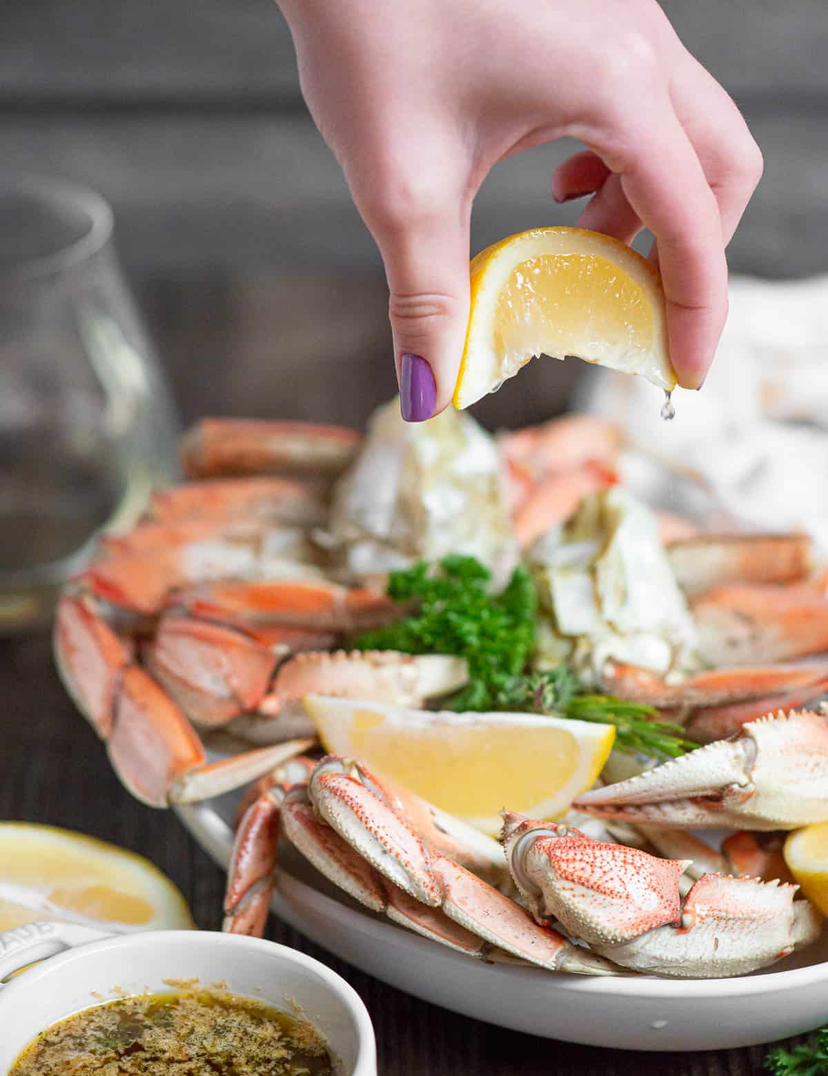 Squeezing lemon on steamed crab legs.