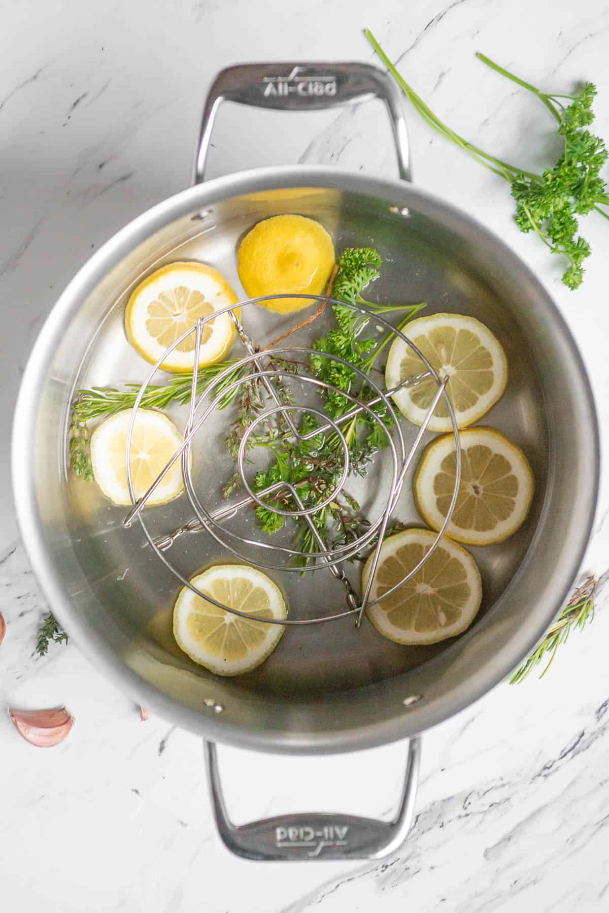 pot with lemon and herbs for steaming crab legs.