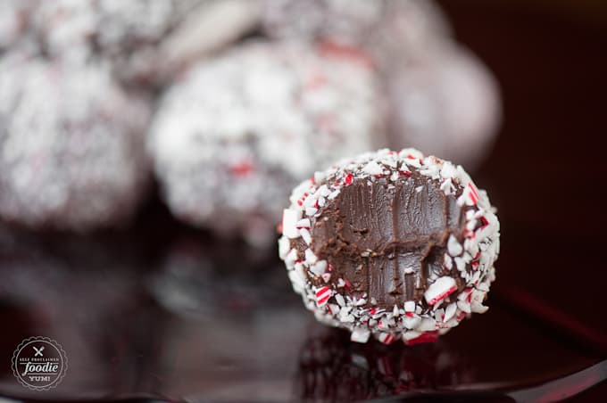 a chocolate candy cane truffle with a bite taken out of it