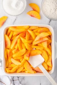 fresh peach slices in baking dish