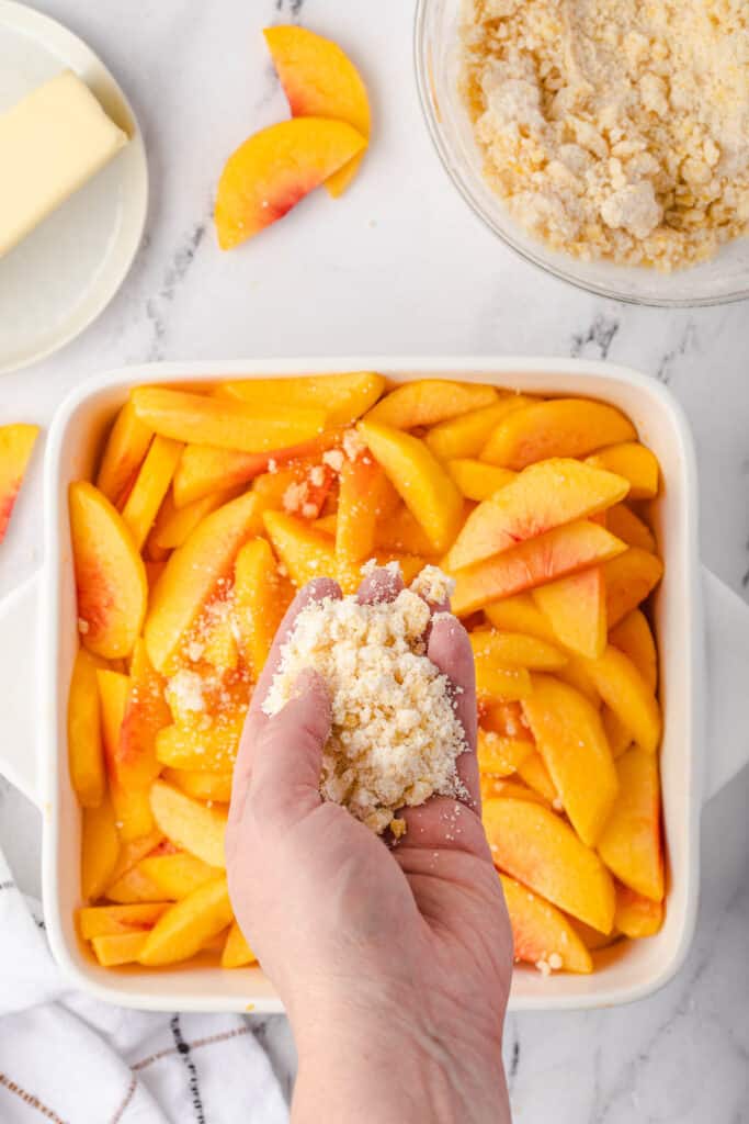 spreading topping on fresh peaches