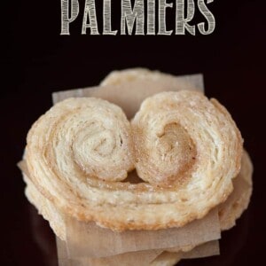 looking down at a stack of Palmier cookies separated with parchment paper