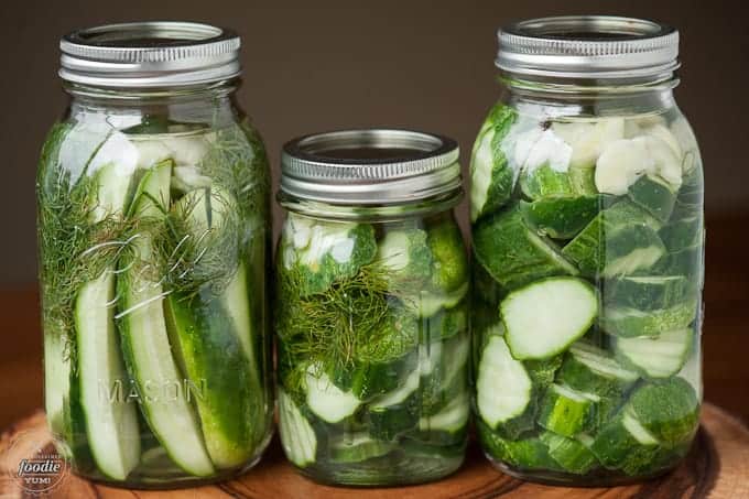 three mason jars filled with homemade refrigerator pickles