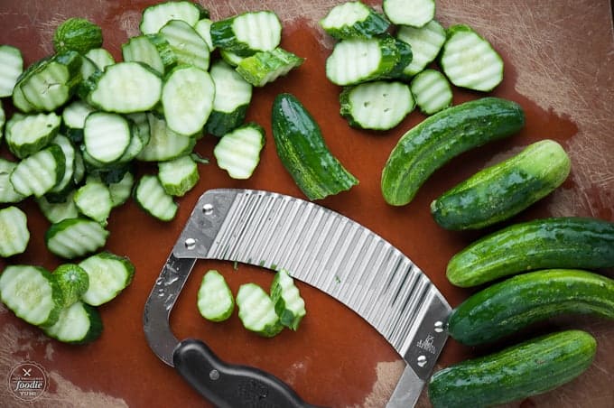 sliced cucumbers on cutting board for pickle recipe
