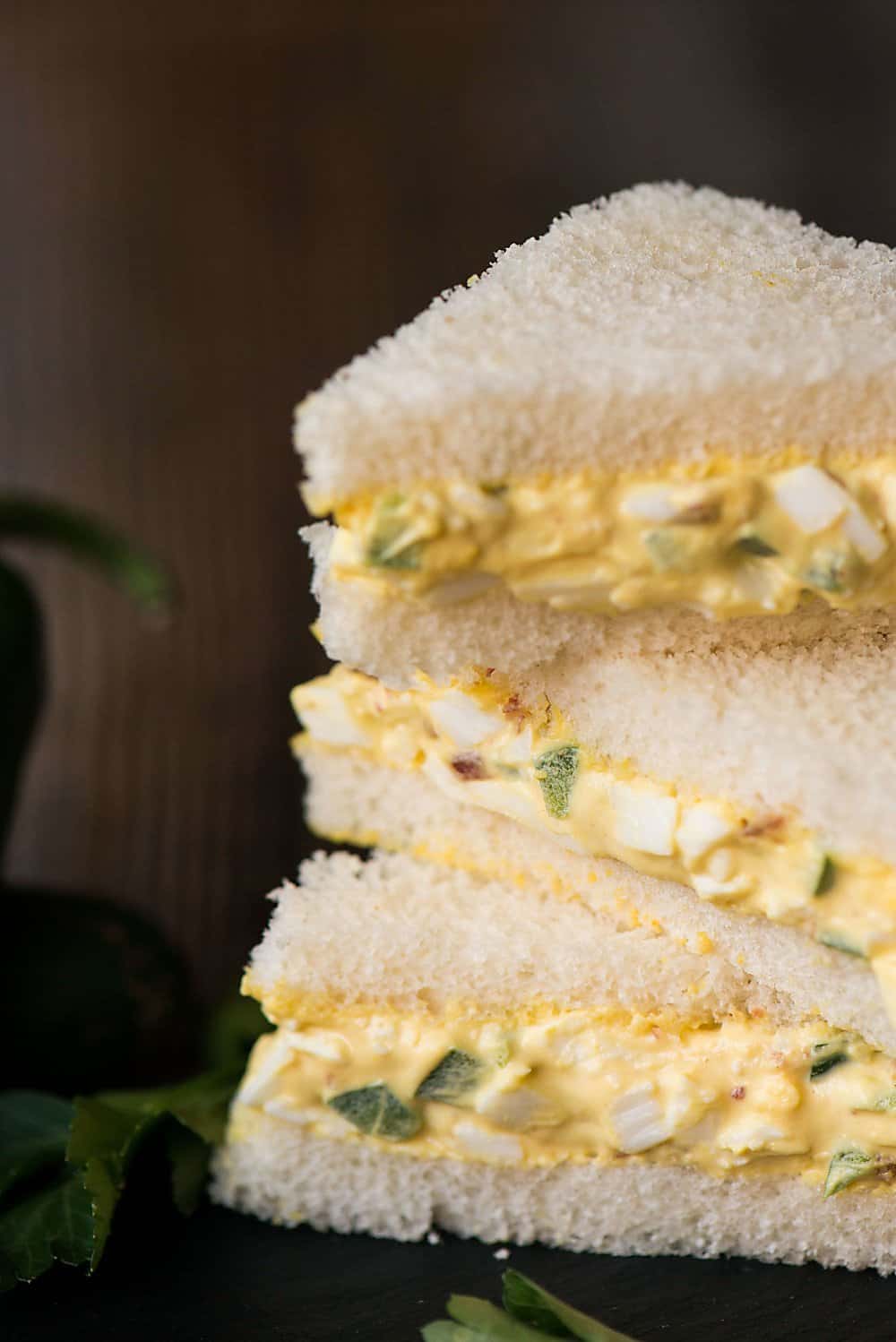 A close up of egg salad sandwiches on top of one another