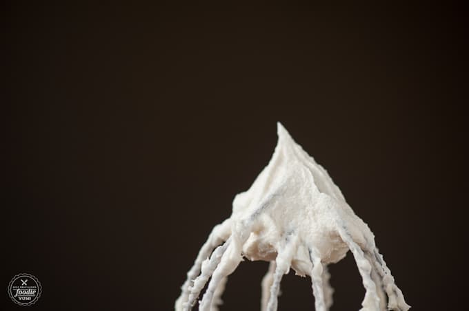 a close up of eggnog frosting on a whisk