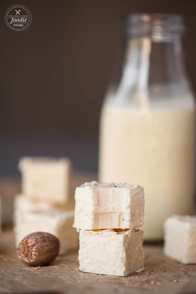 A close up of eggnog fudge with eggnog in the background