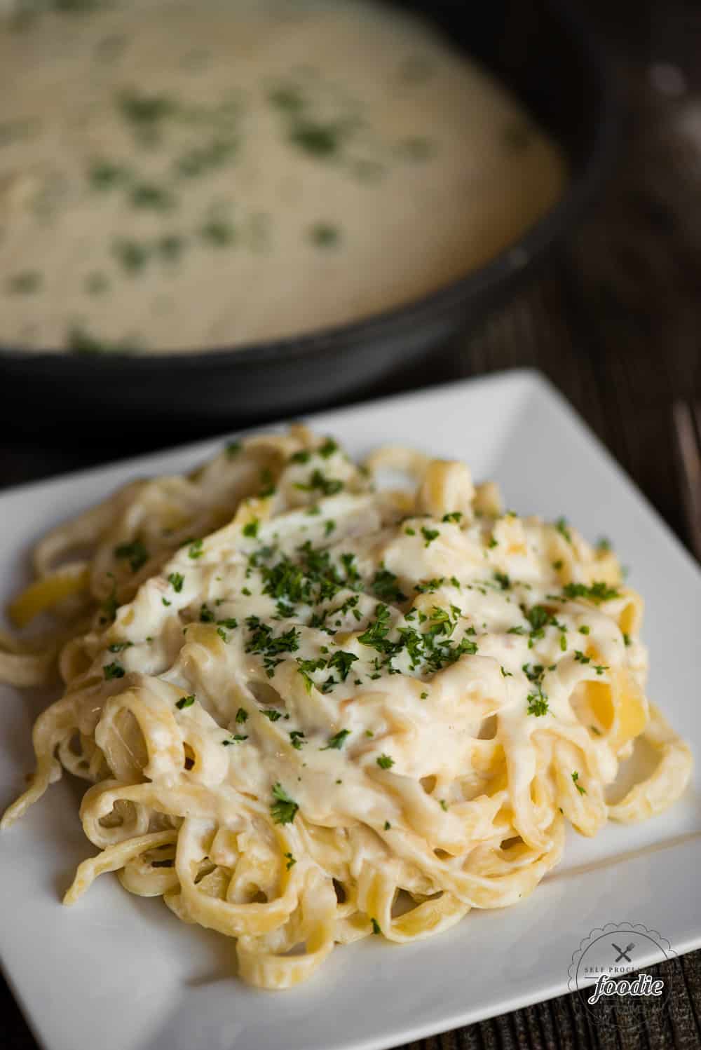 homemade Fettuccine Alfredo on white square plate