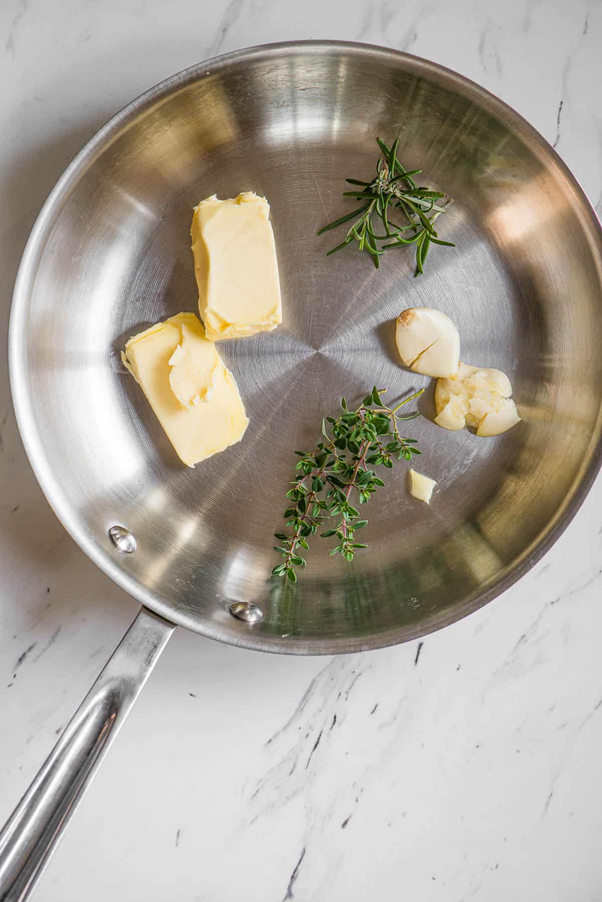 pan with butter and garlic and herbs