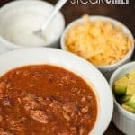 Steak Chili in bowl with sour cream, cheese, and avocado