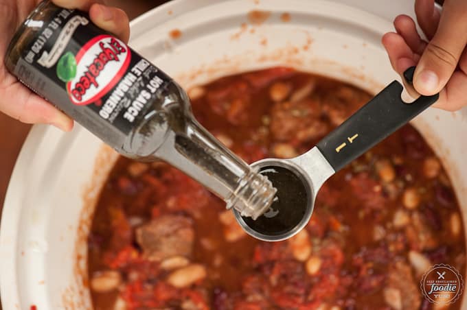 adding hot sauce to Steak Chili 