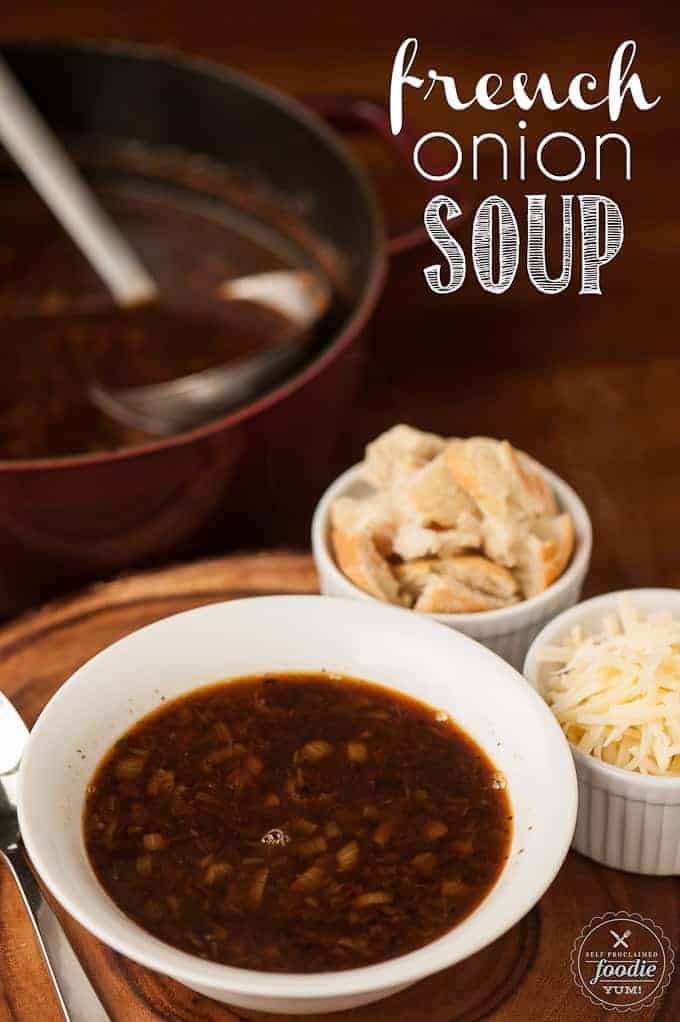 A bowl of French Onion Soup with toasted bread and shredded cheese on the side