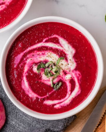 bowl of fresh beet soup garnished with cream.
